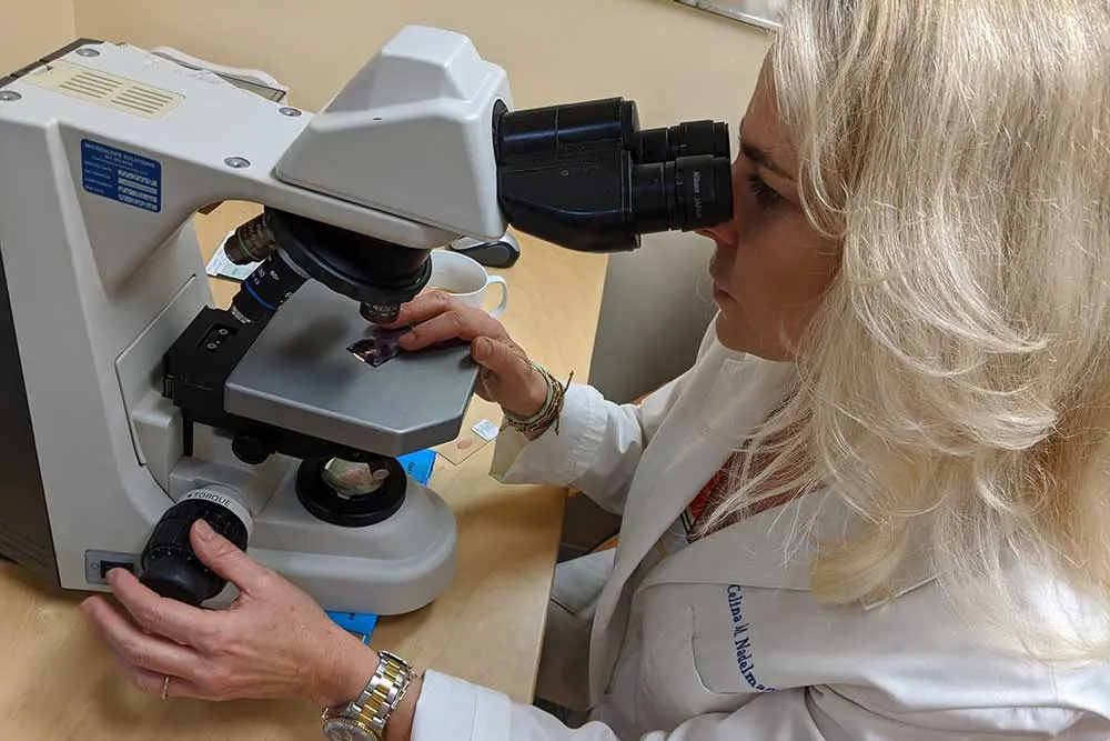 Dr. Nadelman examines a thyroid tissue sample under a microscope to provide accurate cancer diagnosis.