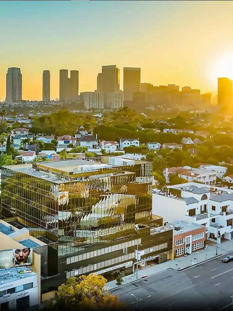 A cityscape at sunset with a modern building reflecting the skyline, highlighting precision and efficiency in medical care, emphasizing the importance of compassionate care in providing fast results for patients.| Dr. Nadelman Biopsy Doctor